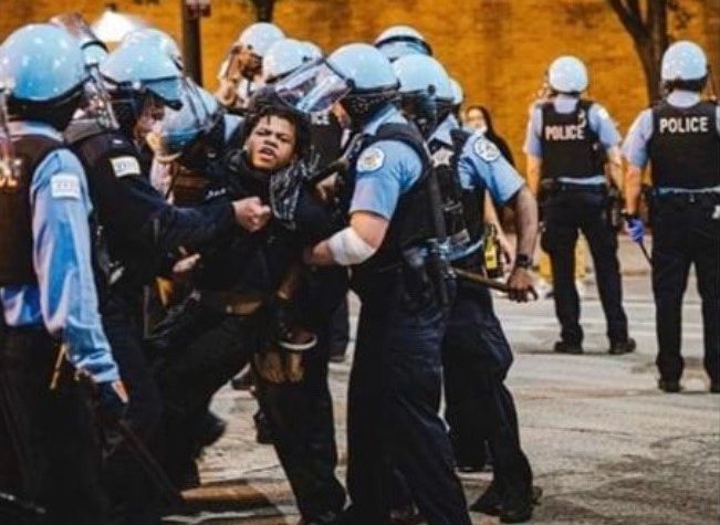 This picture, shared heavily on social media, shows Justin Cosby being forcibly detained by multiple members of the Chicago Police Department.