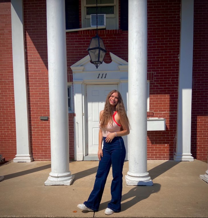 Writer Jeana Pierson stands in front of the Tri Delta house.